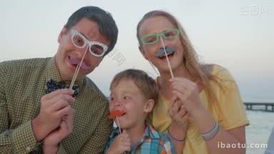 慢镜头，年轻幸福的<strong>三口之家</strong>，戴着时髦的纸眼镜，留着小胡子，在户外玩耍的父母和孩子